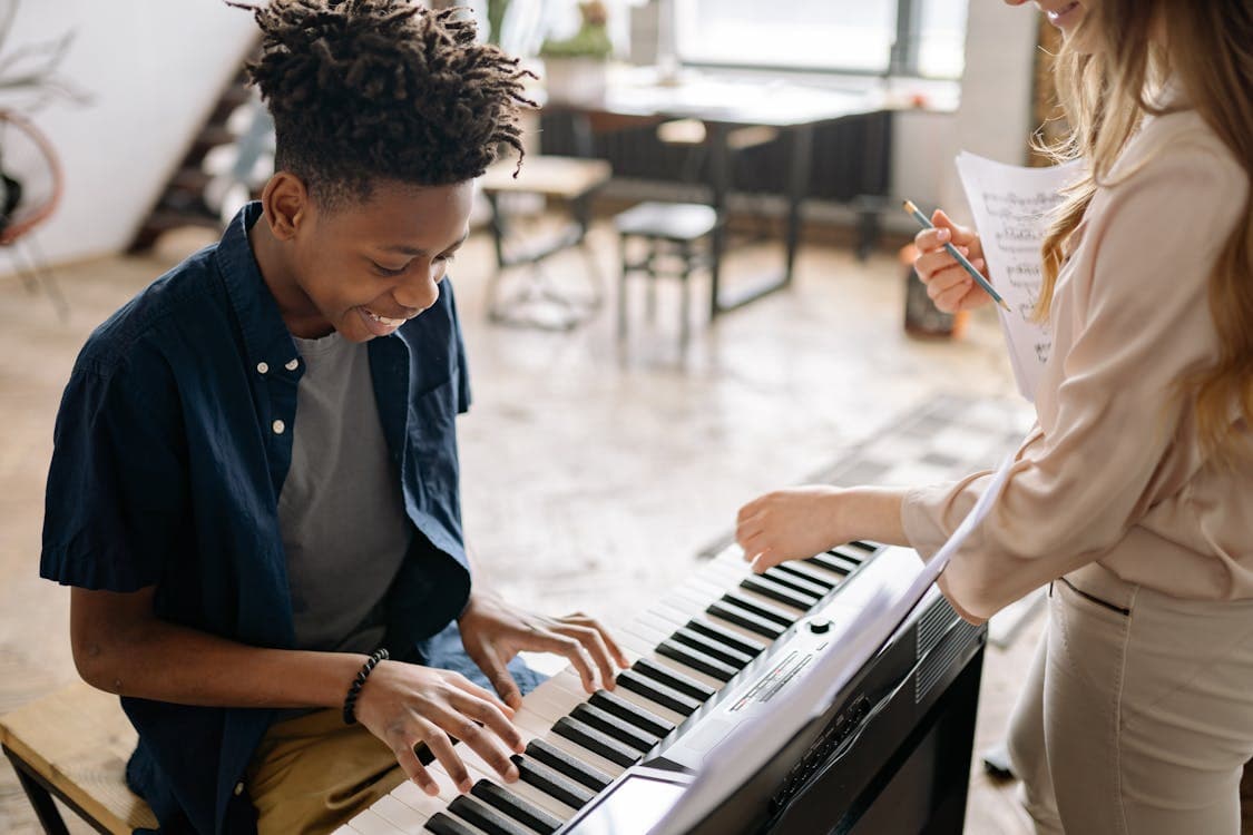 Piano teacher guiding a student during a lesson